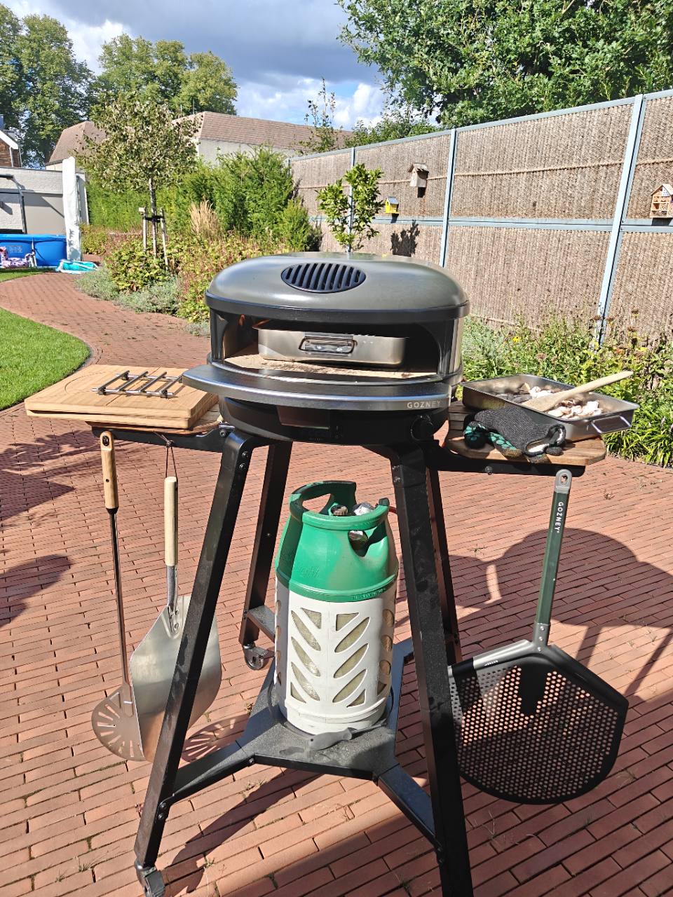 Buitenoven met werkbladen en pizzagereedschap in de tuin